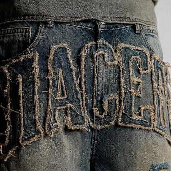 Distressed embroidery technique creating worn, vintage-style stitched detailing on apparel by Hesson Apparel