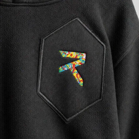 Appliqué embroidery combining fabric layers and stitching for bold apparel designs by Hesson Apparel